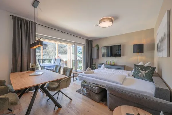 Wohnzimmer mit Schlafsofa und Zugang Terrasse  Mountain Lodge by Alpenidyll Apartments