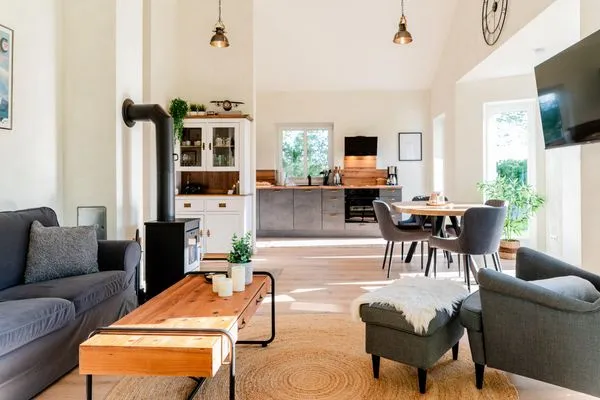Großzügiger Wohnraum mit Essbereich, Küche, Kamin und Sofa  Fördezauber