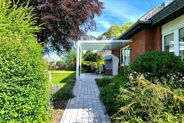Überdachte Terrasse mit Strandkorb und Garten  Ferienhaus Landliv Huus