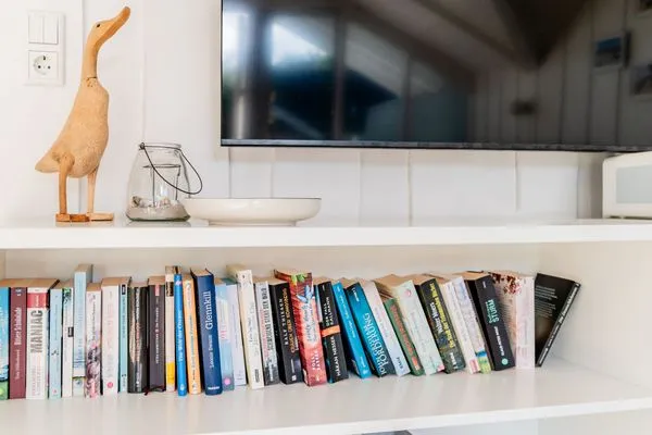 Wohnzimmer mit Bücherauswahl, Spielen, Ofen, TV, Couch, Relaxsessel  Lille Hus