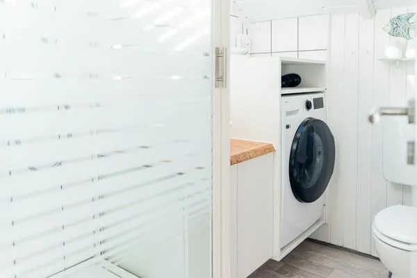 Bad mit Dusche, WC, Fenster, Waschtisch und Waschmaschine  Lille Hus
