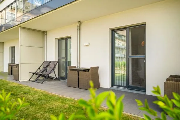 Ferienapartment Ostseestuv Wustrow – Sonnige Terrasse mit gemütlicher Sitzlounge und Blick ins Grüne  Ostseestuv