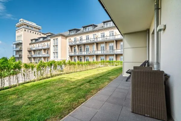 Ferienapartment Ostseestuv Wustrow – Sonnige Terrasse mit gemütlicher Sitzlounge und Blick ins Grüne  Ostseestuv