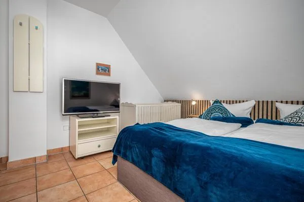 Schlafzimmer mit Doppelbett, Babybett und TV Ferienpark Freesenbruch Doppelhaushälfte 9a - Leuchtturm