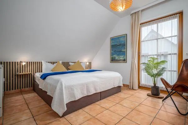 Schlafzimmer mit Doppelbett, Babybett und TV Ferienpark Freesenbruch Doppelhaushälfte 9a - Leuchtturm