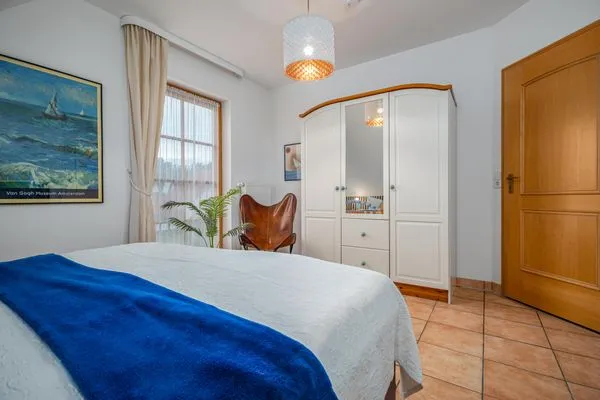 Schlafzimmer mit Doppelbett, Babybett und TV Ferienpark Freesenbruch Doppelhaushälfte 9a - Leuchtturm