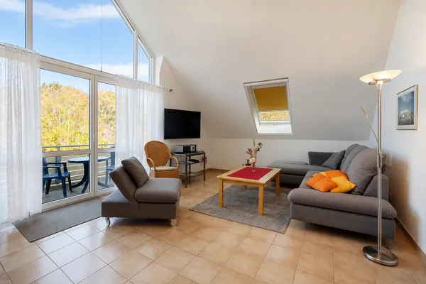 Wohnbereich mit Sofa und Blick zum Balkon Residenz am Strand Wohnung 1-16
