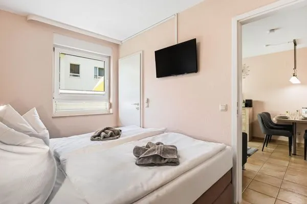 Schlafzimmer mit Doppelbett und TV Residenz am Strand Wohnung 4-57