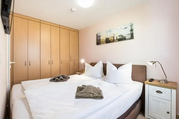 Schlafzimmer mit Doppelbett und TV Residenz am Strand Wohnung 4-57
