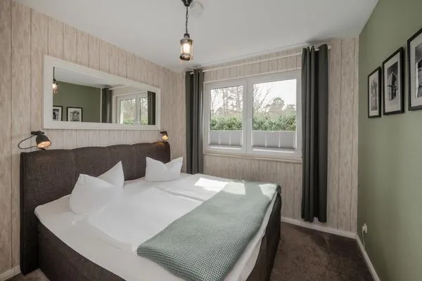 Schlafzimmer  Ferienwohnung Strandläufer mit Badewanne, Terrasse mit Grill und Strandkorb