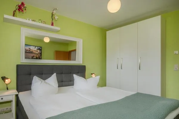 Schlafzimmer  Ferienwohnung Strandläufer mit Badewanne, Terrasse mit Grill und Strandkorb