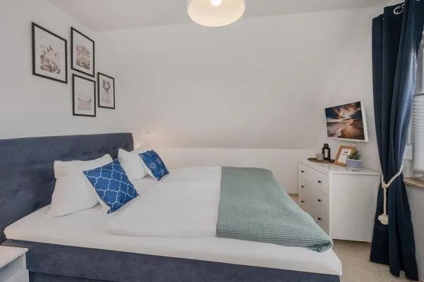 Schlafzimmer  Ferienwohnung Strandlerche mit Balkon, Badewanne und Dusche