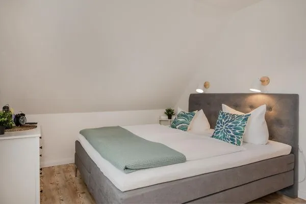 Schlafzimmer  Ferienwohnung Strandlerche mit Balkon, Badewanne und Dusche