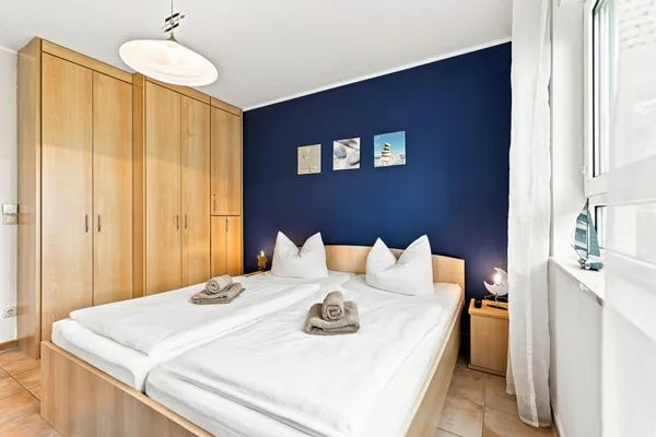 Schlafzimmer mit Doppelbett, Kleiderschrank und TV Residenz am Strand Wohnung 4-58