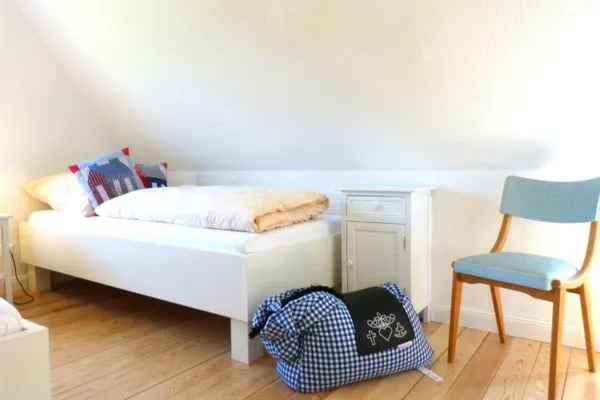 Einzelbett mit Stuhl im Ferienhaus Koggenhüs in Norddorf auf Amrum  Ferienhaus *Koggenhüs*