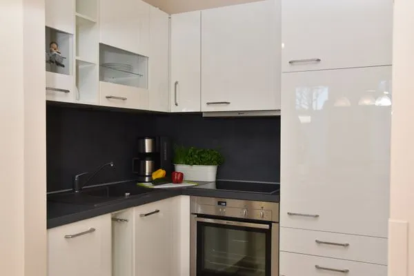 offene Küchenzeile mit Spüle, Backofen, Kochfeld, Spülmaschine, Kühlschrank und Kaffeemaschine Logierhaus Friedrich WE 3 - "Klaas Störtebecker"