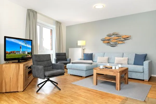 Geschmackvoll eingerichtetes Wohnzimmer mit traumhaftem Meerblick. Haus Südwester Ringelrobbe