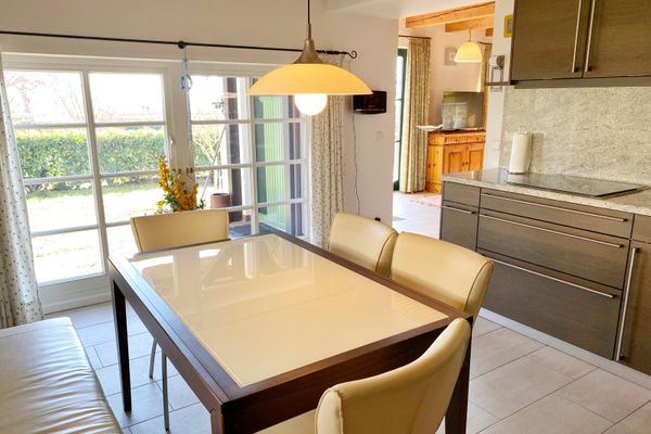 Küche mit großem Esstisch und vorgelagerter Terrasse