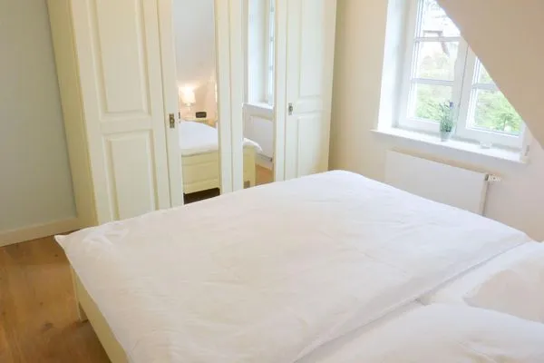 Schlafzimmer mit Blick in den Garten in der Ferienwohnung Seepferdchen in Süddorf auf Amrum Heidehüs Friesenhaushälfte *Seepferdchen*