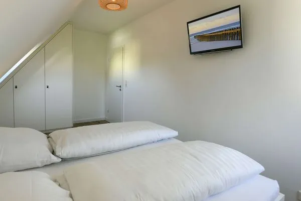 Schlafzimmer mit TV Haus am Dorfbrunnen Ferienwohnung Meer
