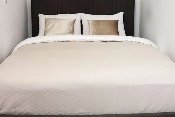 Doppelbett mit Kissen im Schlafzimmer  Strandnahe Souterrain-Ferienunterkunft - Mit gratis Bettwäsche-Paket