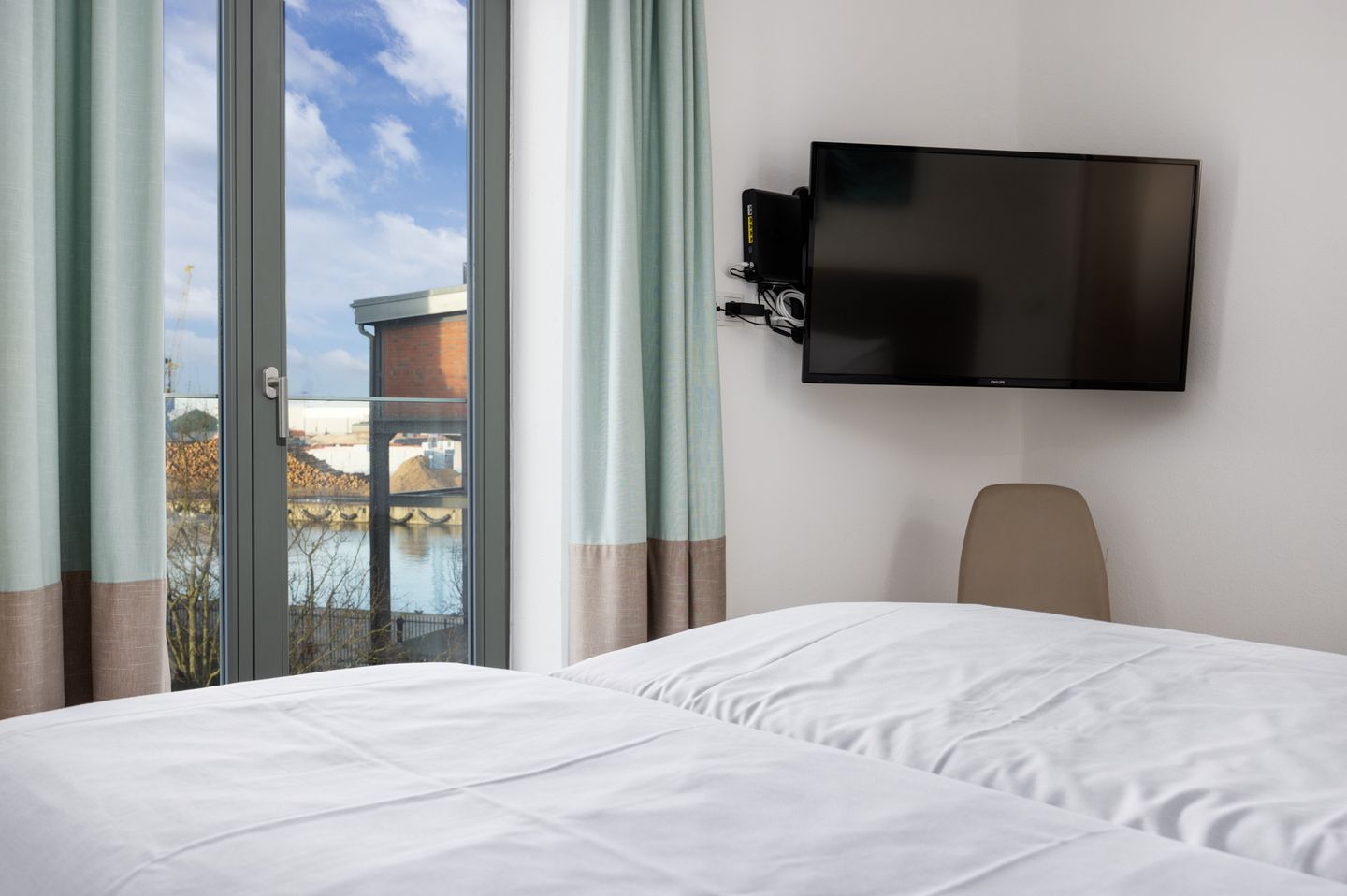 Ohlerich Speicher Ohlerich Speicher 2-13 Wismar - Schlafzimmer mit Doppelbett, TV und Zugang zum Balkon