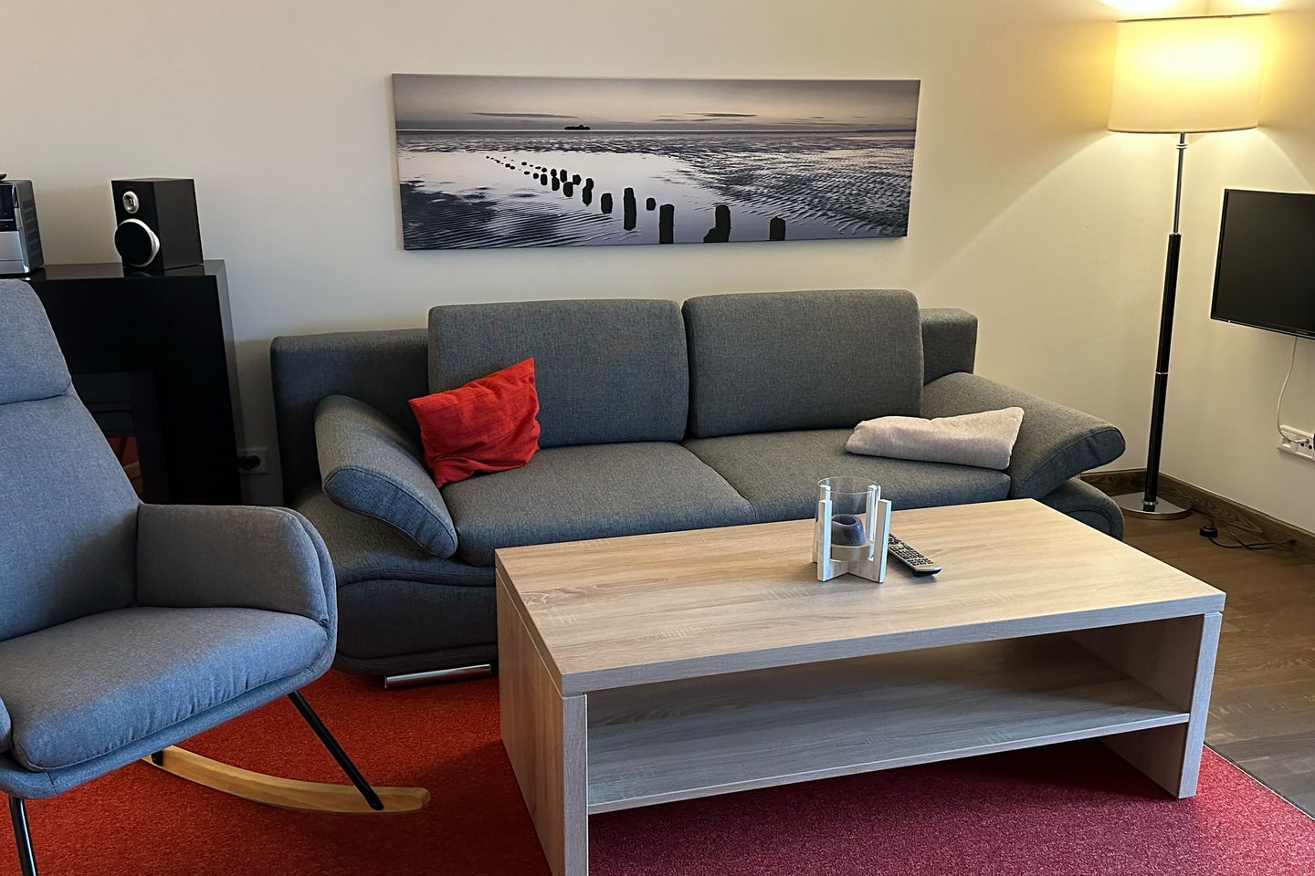 Resort Deichgraf Resort Deichgraf 27-01 Wremen - Wohnbereich mit Couch, Schaukelstuhl, Flatscreen TV und Zugang zur Terrasse