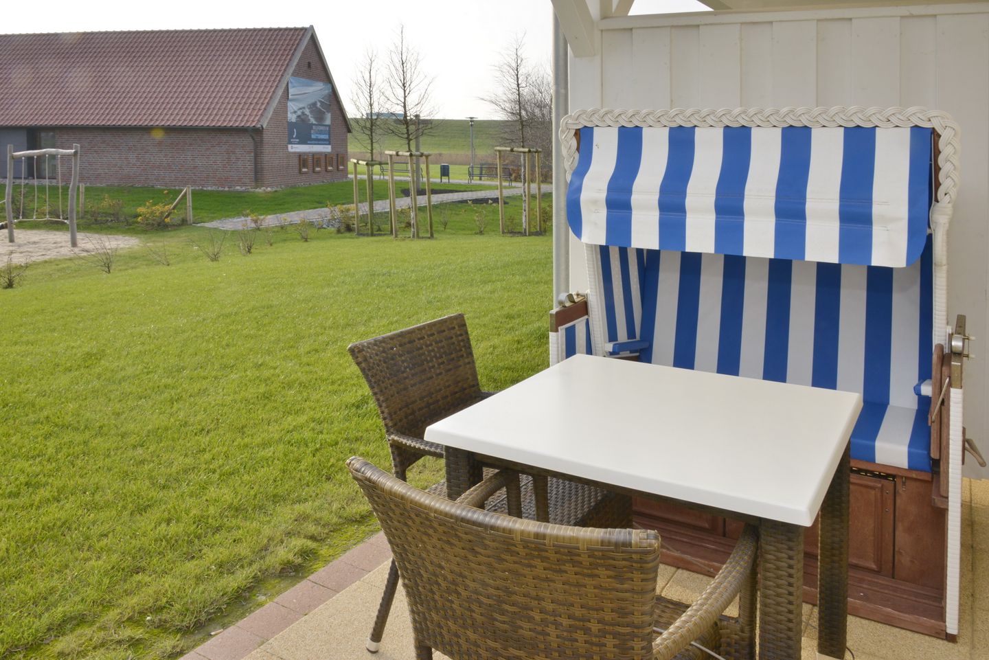 Resort Deichgraf Resort Deichgraf 27-01 Wremen - Terrasse mit Strandkorb und Sitzgelegenheit