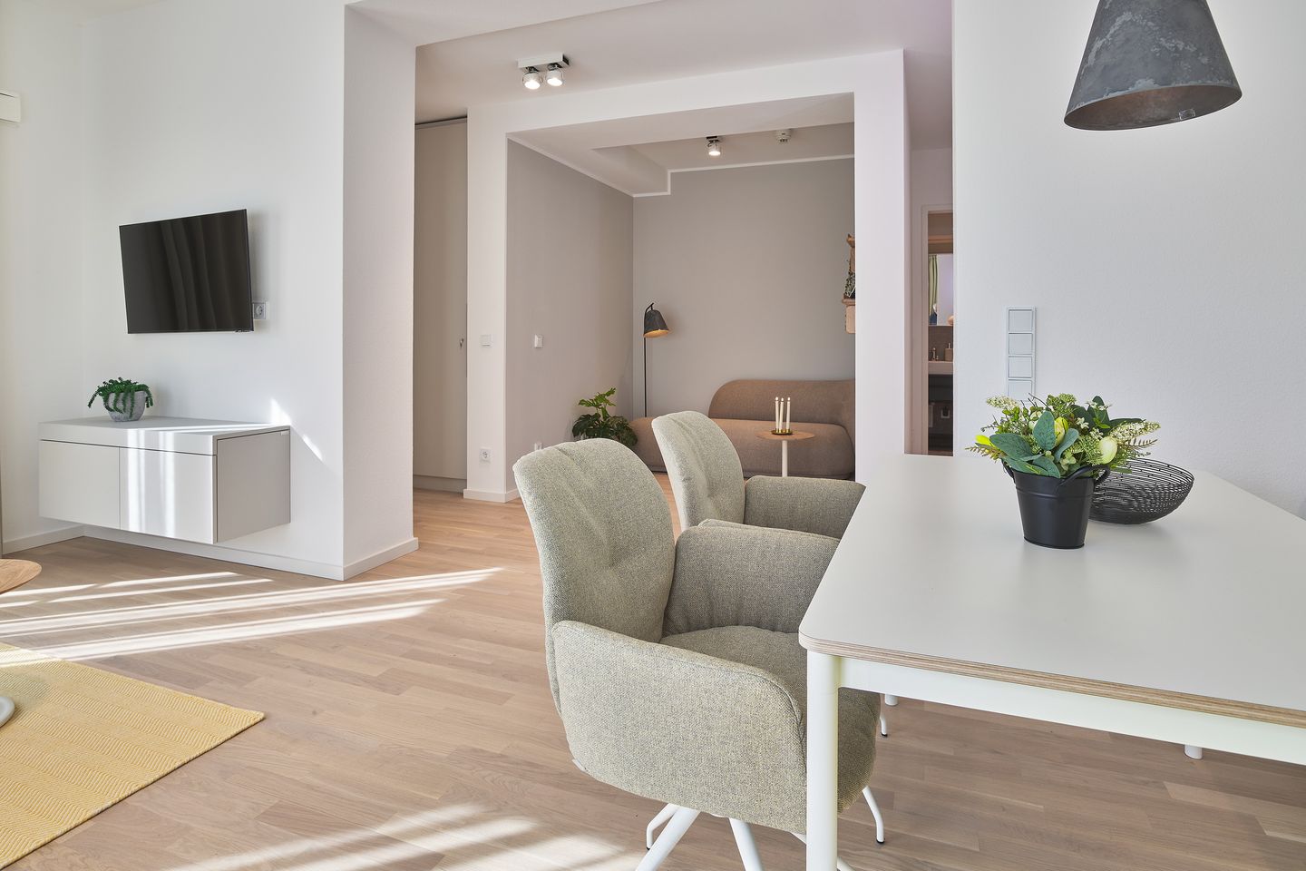 Lüttjeod Apartmentvilla Lüttjeod Apartmentvilla 02 Langeoog - Wohn-Essbereich mit Flatscreen-TV, Esstisch und Blick in den Flur