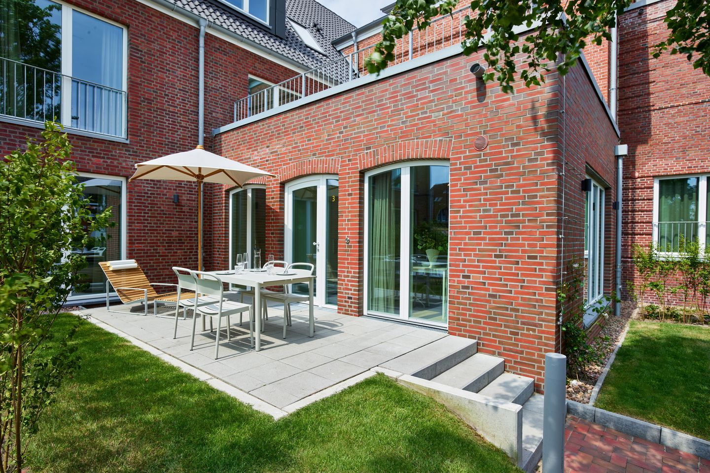 Lüttjeod Apartmentvilla Lüttjeod Apartmentvilla 03 Langeoog - Terrasse mit Gartenmöbeln und Grünfläche