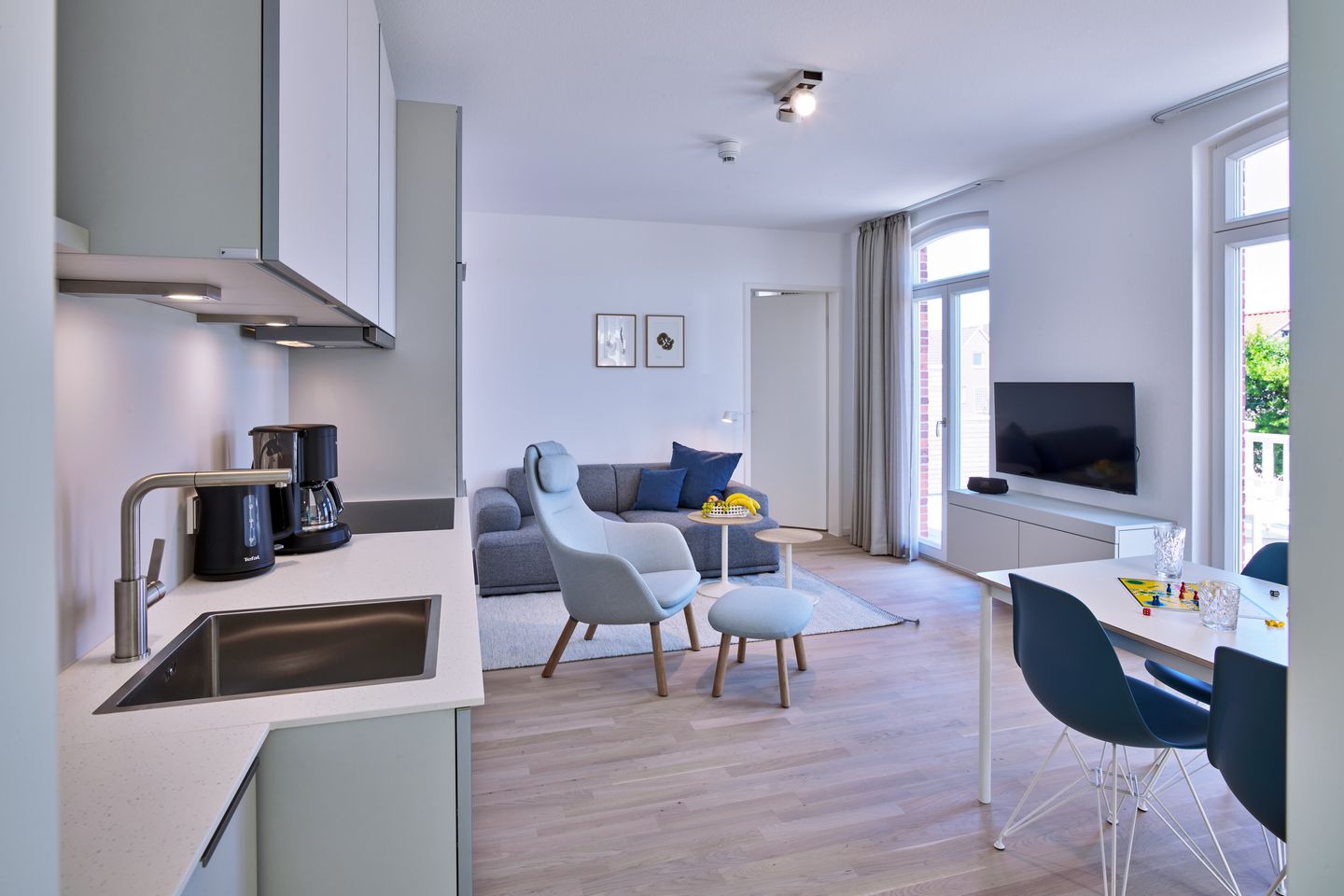 Lüttjeod Apartmentvilla Lüttjeod Apartmentvilla 08 Langeoog - Wohn-Essbereich mit Couch, Esstisch, Sitzgelegenheit und Küchenzeile