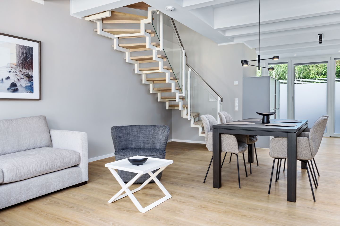 Strandresidenzen Binz-Prora Strandresidenzen Binz-Prora D0.2 Rügen - Wohn-Essbereich mit Couch, Esstisch und Treppenaufgang