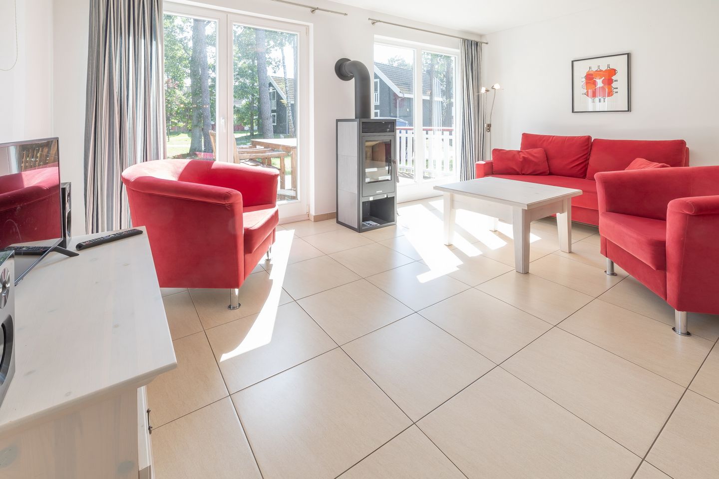 Ostseepark Rügen Ostseepark Rügen 25 Rügen - Wohn-Essbereich mit Couch, Kamin und Zugang zur Terrasse