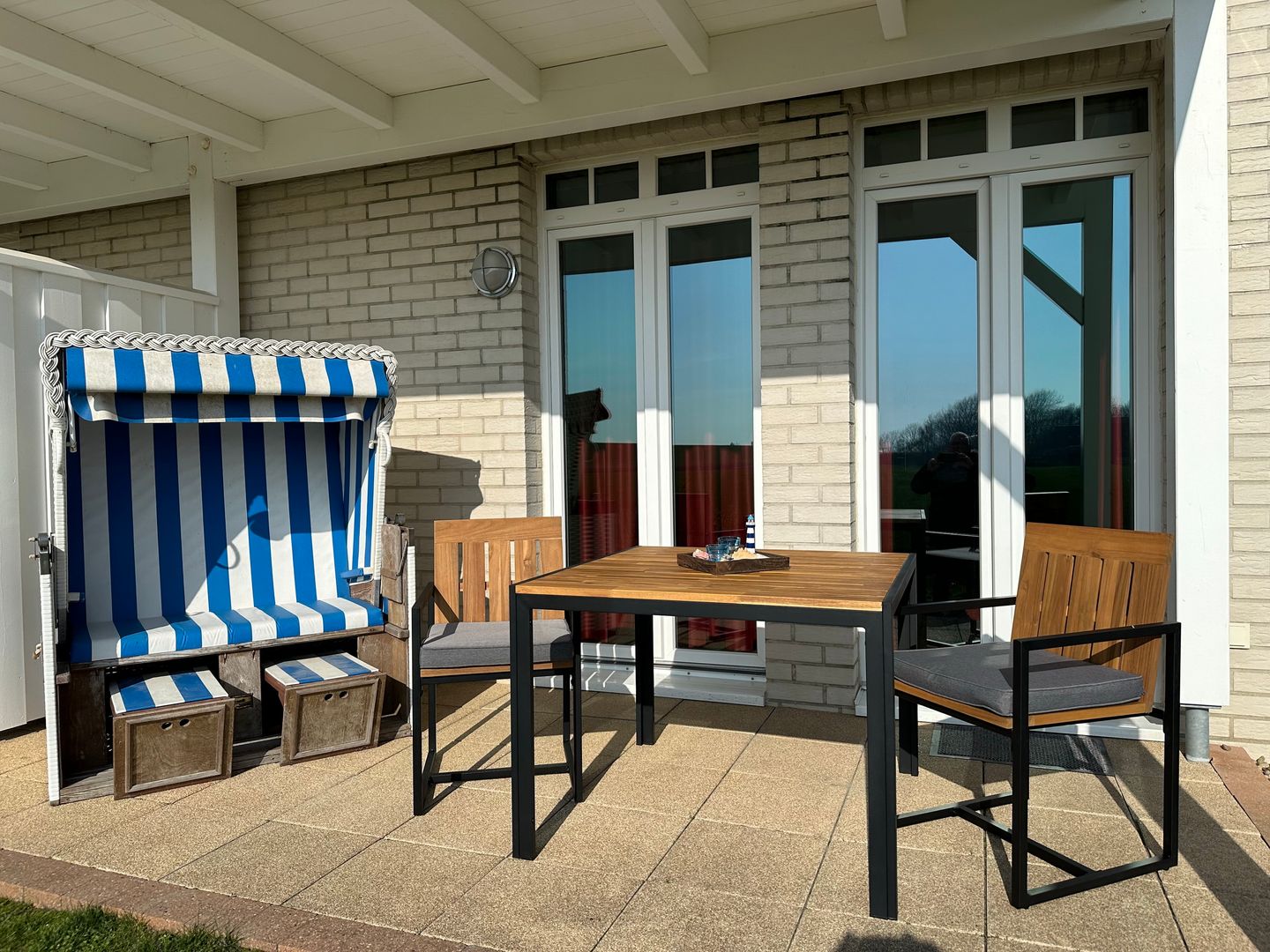 Resort Deichgraf Resort Deichgraf 31-04 Wremen - Überdachte Terrasse mit Strandkorb, Sitzgelegenheit und Grünfläche