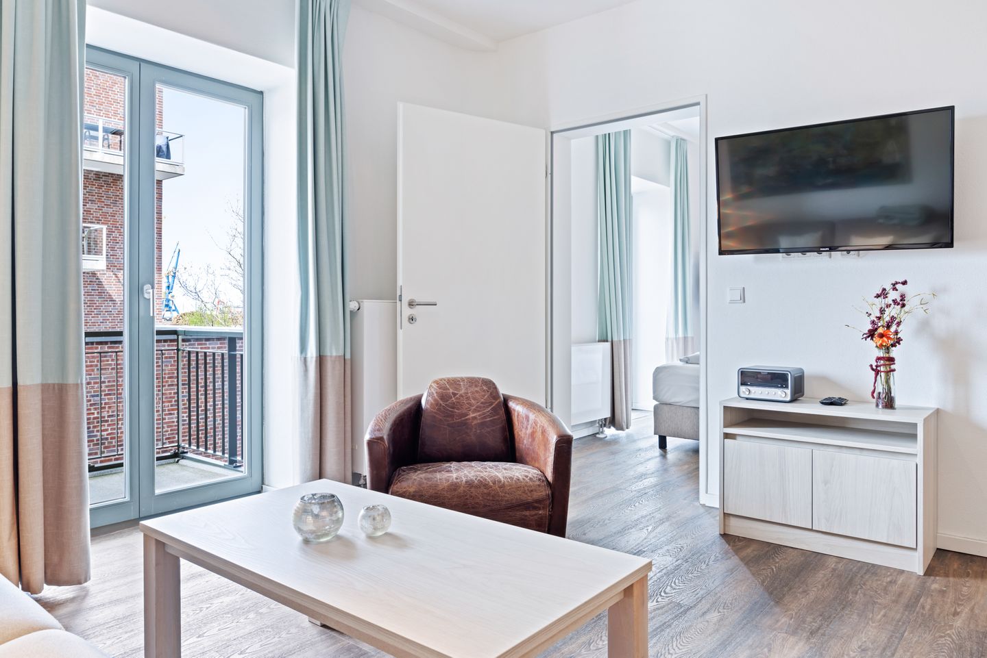 Ohlerich Speicher Ohlerich Speicher 1-06 Wismar - Wohn-Essbereich mit Couch und Flatscreen-TV