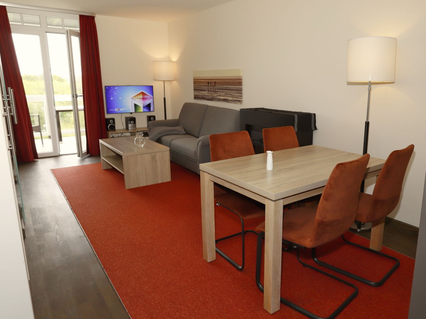 Resort Deichgraf Resort Deichgraf 31-12 Wremen - Wohn-Essbereich mit Couch, Esstisch und Kamin