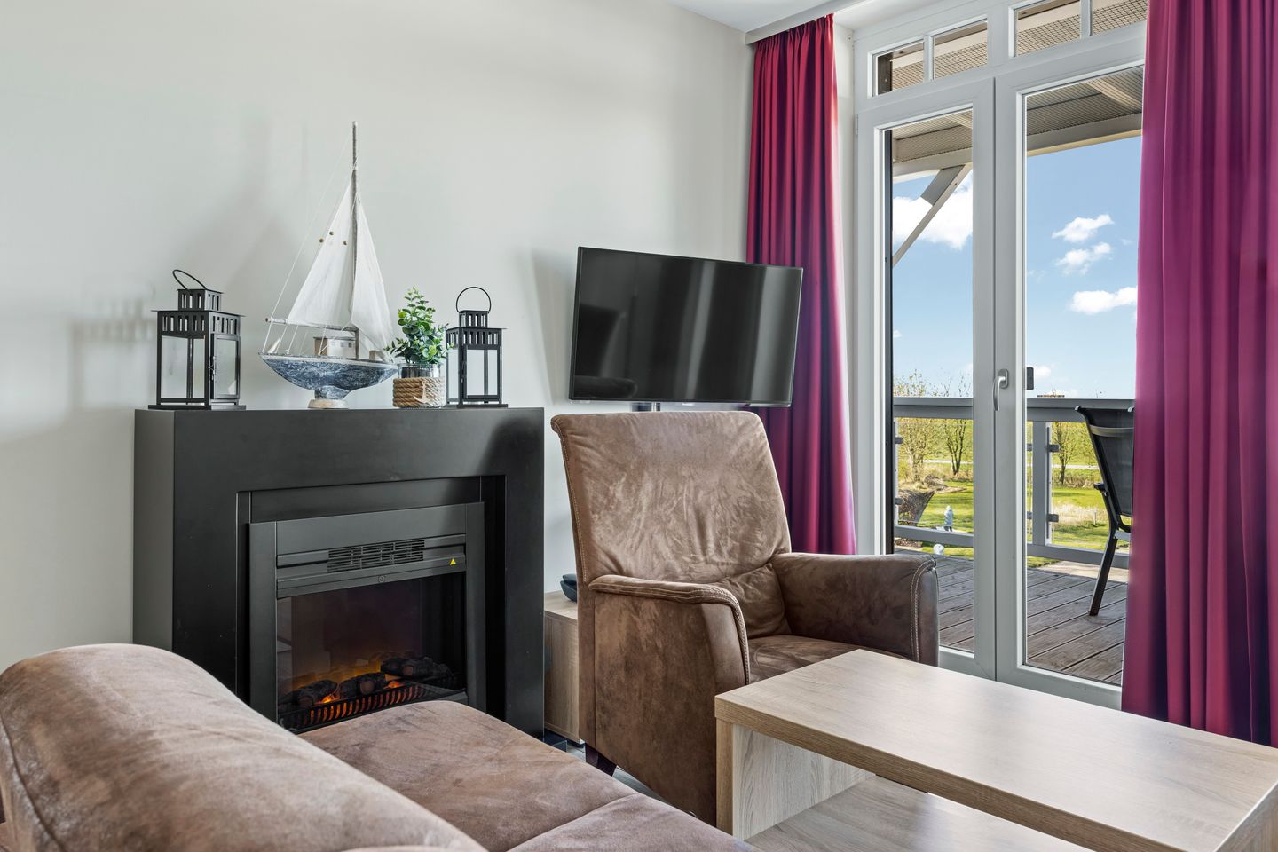 Resort Deichgraf Resort Deichgraf 27-14 Wremen - Wohnbereich mit Kamin und TV