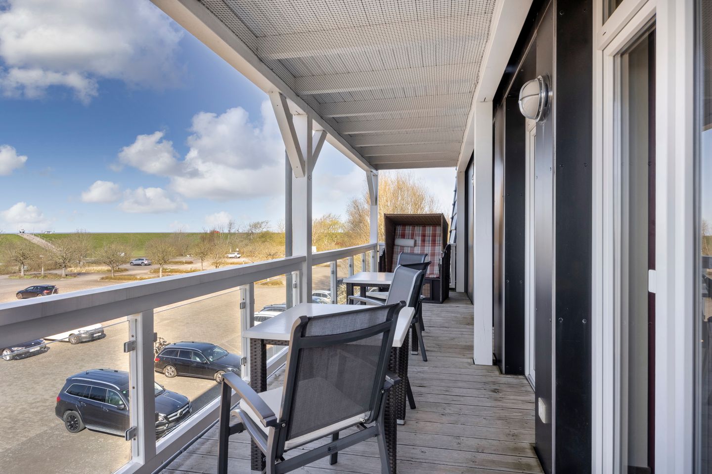 Resort Deichgraf Resort Deichgraf 27-14 Wremen - Überdachter Balkon mit Sitzgelegenheit und Strandkorb
