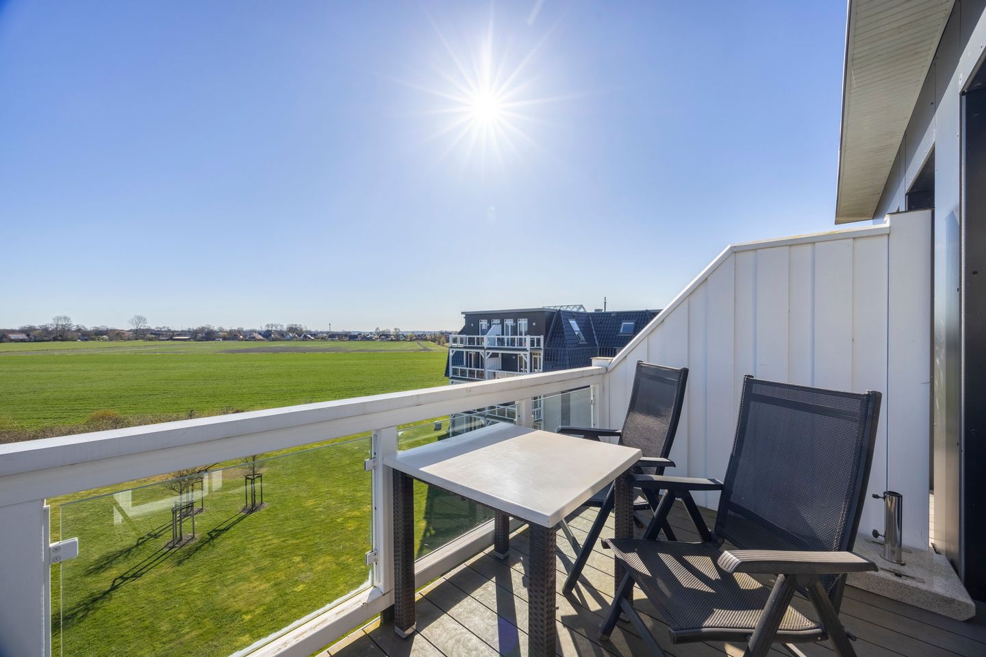 Resort Deichgraf Resort Deichgraf 27-21 Wremen - Balkon mit Tisch, Sitzgelegenheiten und Blick ins Grüne