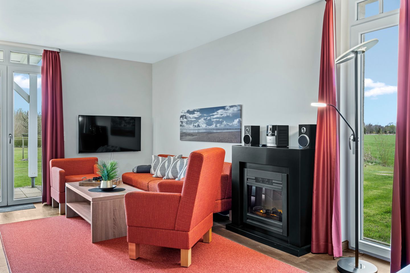 Resort Deichgraf Resort Deichgraf 31-02 Wremen - Wohnbereich mit Sofa, Sessel, Couchtisch und Kamin