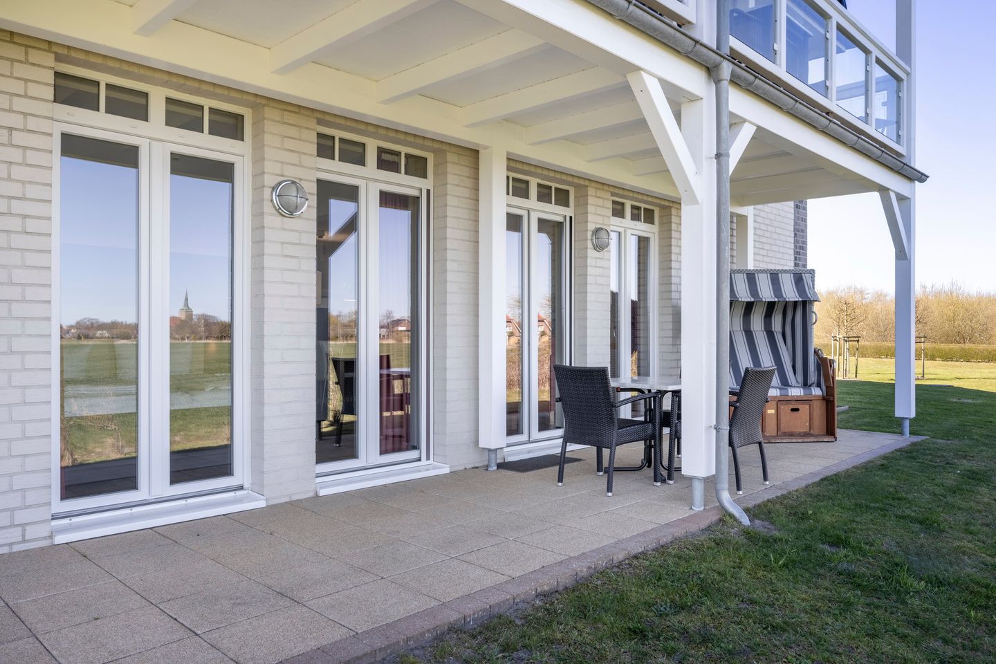 Resort Deichgraf Resort Deichgraf 31-03 Wremen - Überdachte Terrasse mit Sitzgelegenheit und Strandkorb