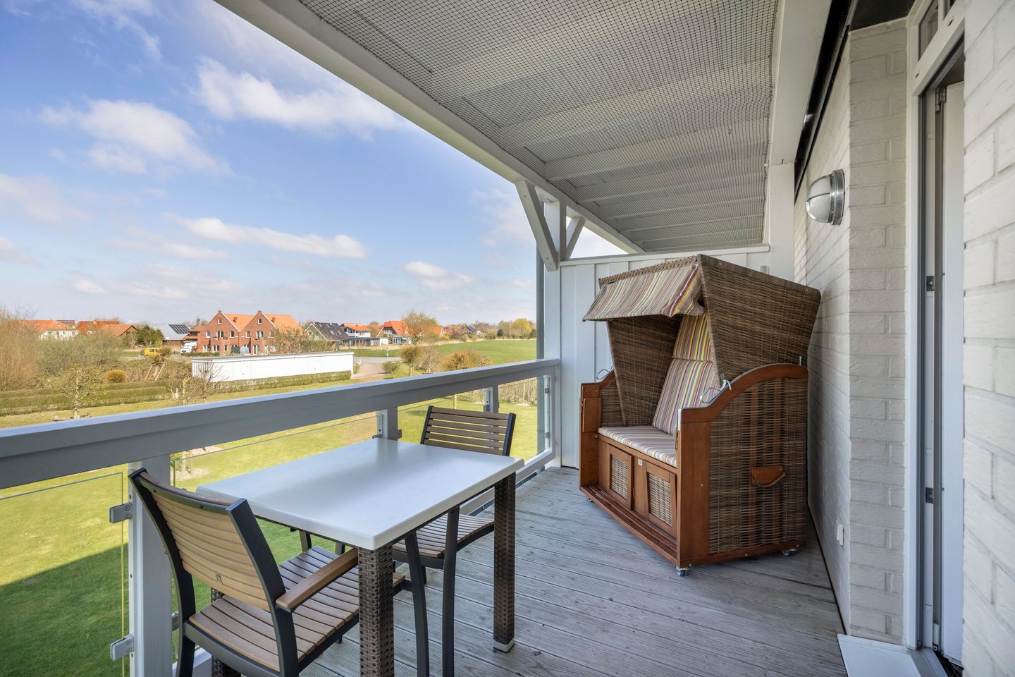 Resort Deichgraf Resort Deichgraf 31-06 Wremen - Überdachter Balkon mit Sitzgelegenheit und Strandkorb