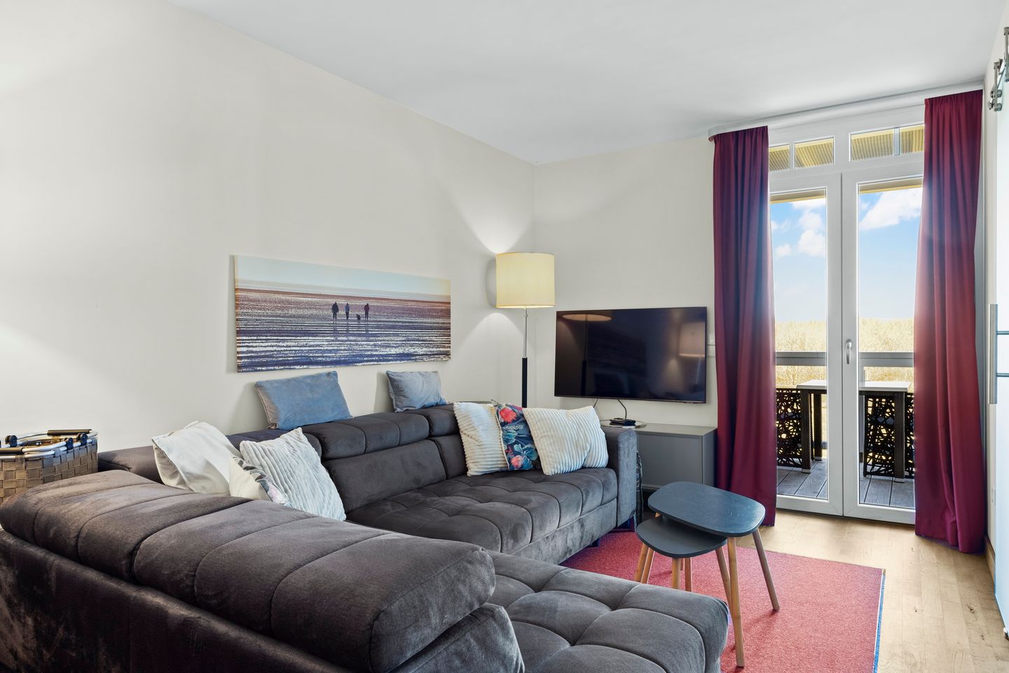 Resort Deichgraf Resort Deichgraf 31-07 Wremen - Wohnbereich mit Sofa, Couchtisch, TV und Zugang zum Balkon