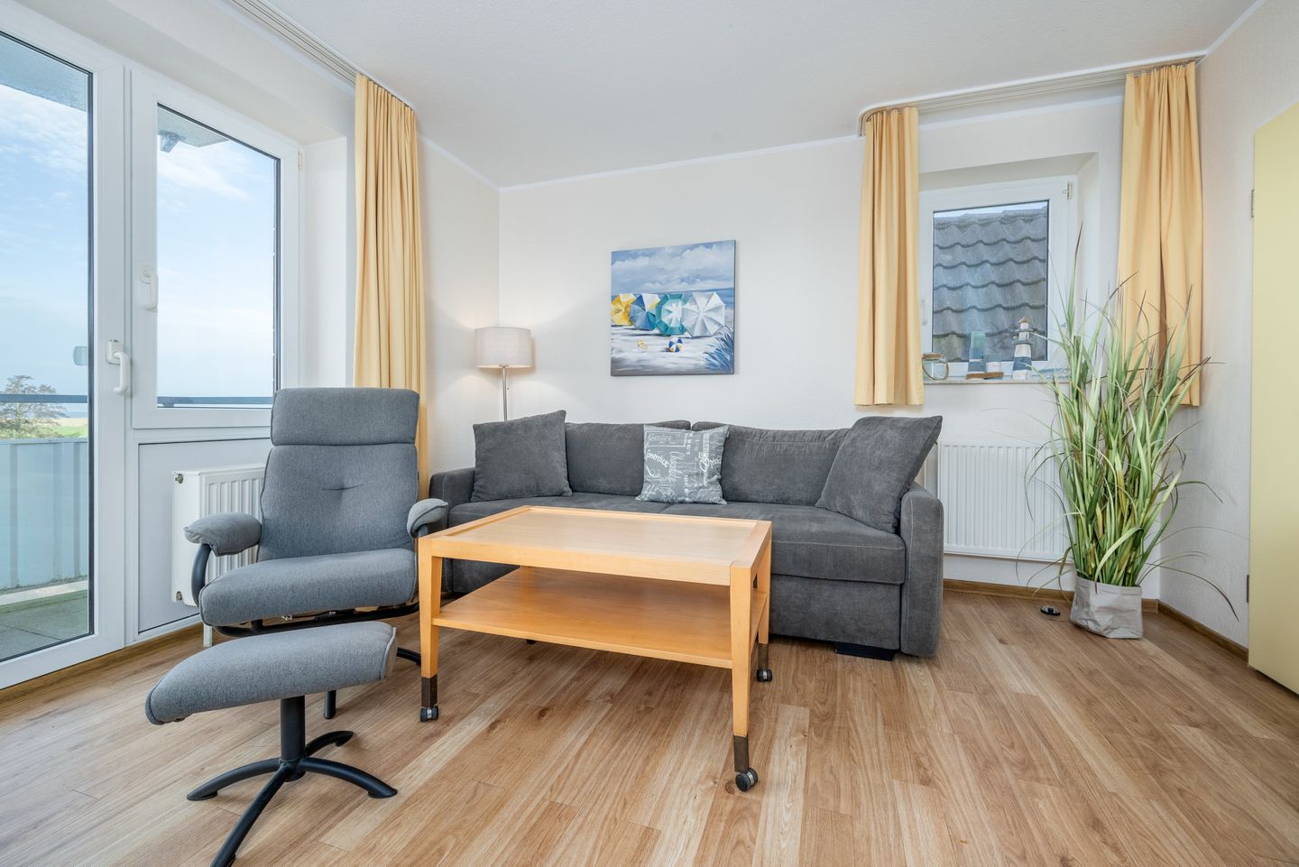 Hus Inselkieker Hus Inselkieker 322 Schillig - Wohn-Essbereich mit Couch und Sessel mit Fußstütze