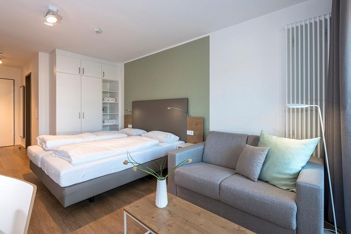 Apartmentvilla Anna See Apartmentvilla Anna See 2-14 Langeoog - Wohnbereich mit Doppelschlafcouch, Kleiderschrank und Boxspringbett