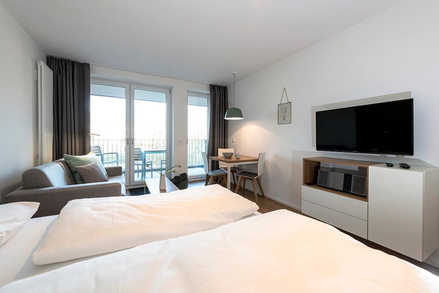 Apartmentvilla Anna See Apartmentvilla Anna See 2-14 Langeoog - Wohnbereich mit Boxspringbett, Sitzgelegenheit und TV