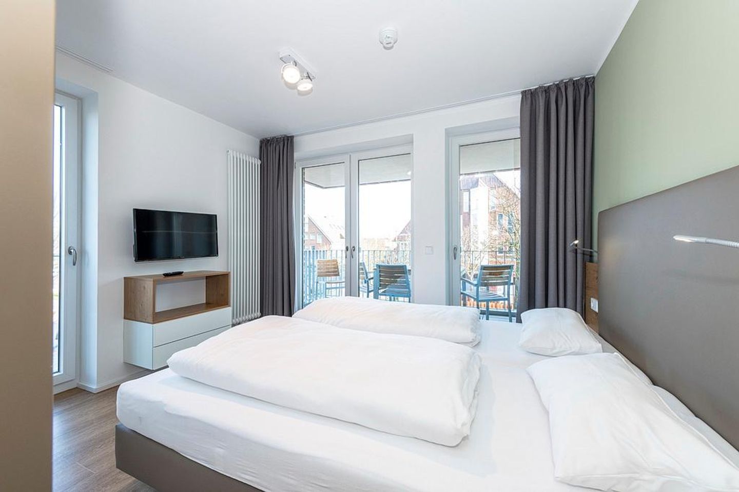 Apartmentvilla Anna See Apartmentvilla Anna See 2-15 Langeoog - Schlafzimmer mit Zugang zum Balkon und TV