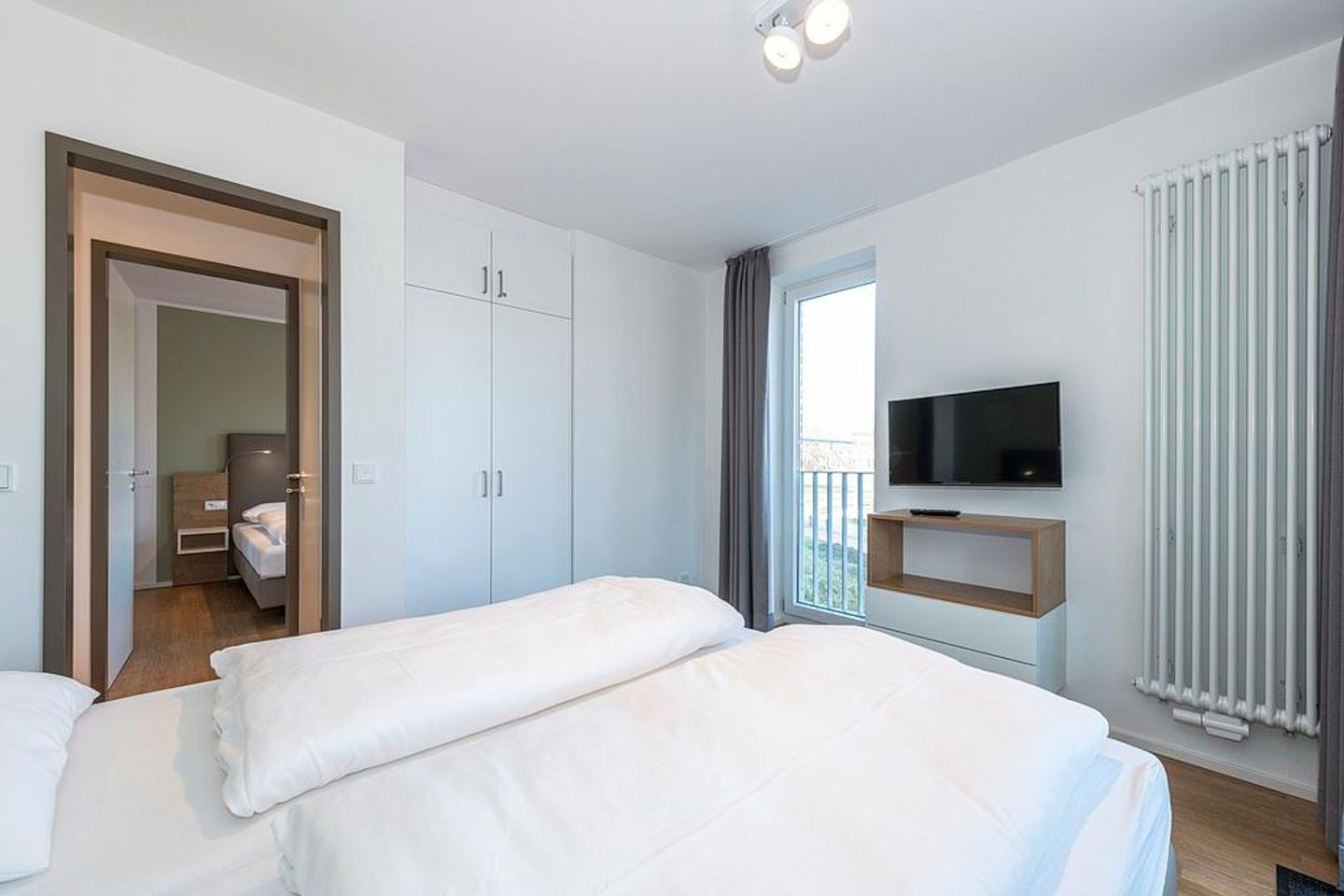 Apartmentvilla Anna See Apartmentvilla Anna See 2-15 Langeoog - Schlafzimmer mit Boxspringbett, Kleiderschrank und TV