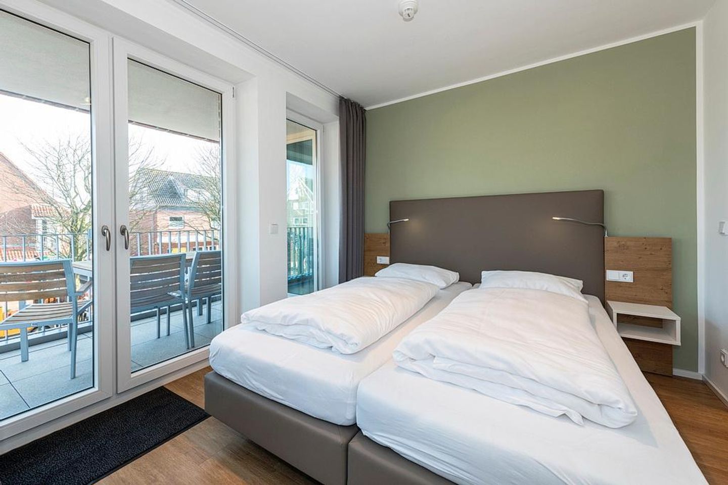 Apartmentvilla Anna See Apartmentvilla Anna See 2-15 Langeoog - Schlafzimmer mit Boxspringbett und Zugang zum überdachten Balkon