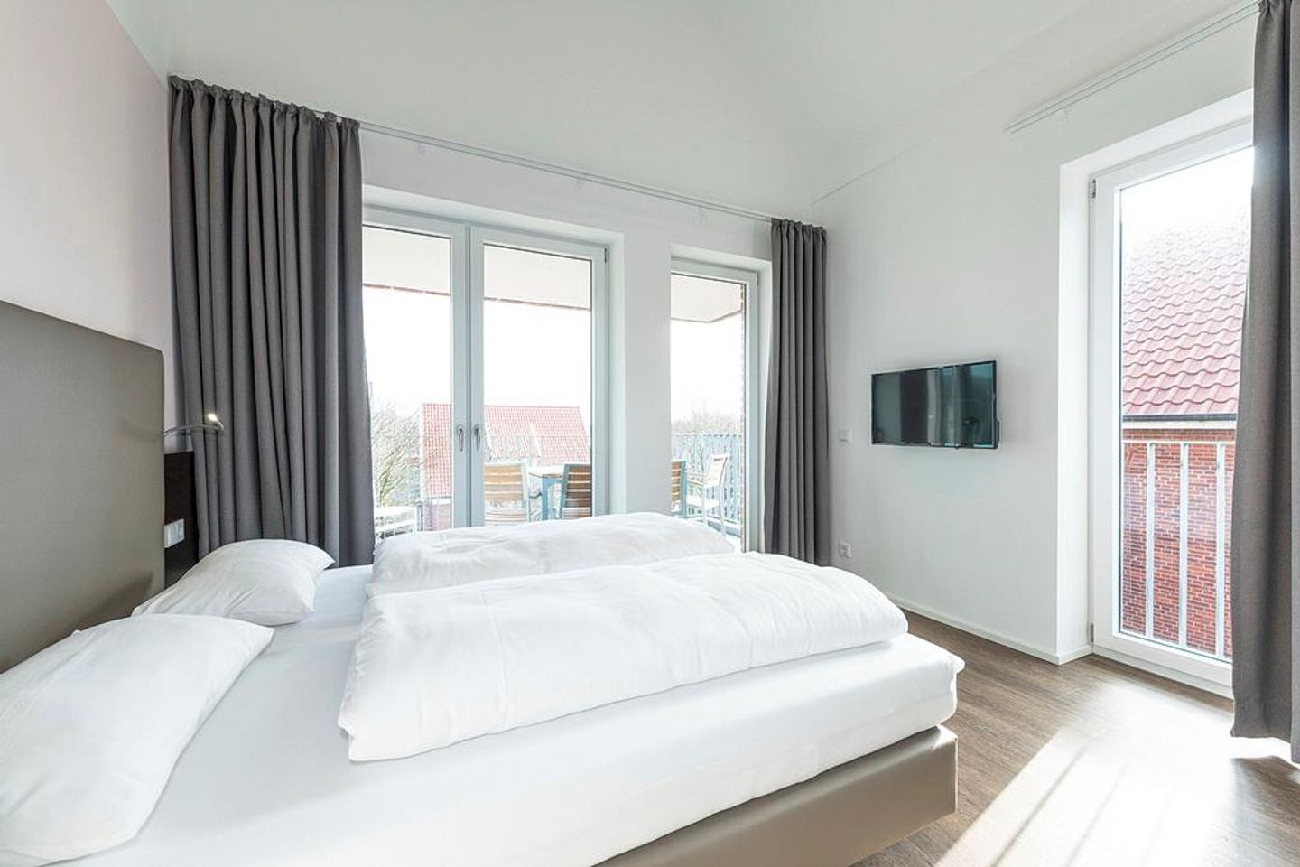 Apartmentvilla Anna See Apartmentvilla Anna See 3-02 Langeoog - Schlafzimmer mit Doppelbett, Kleiderschrank und Zugang zum überdachten Balkon